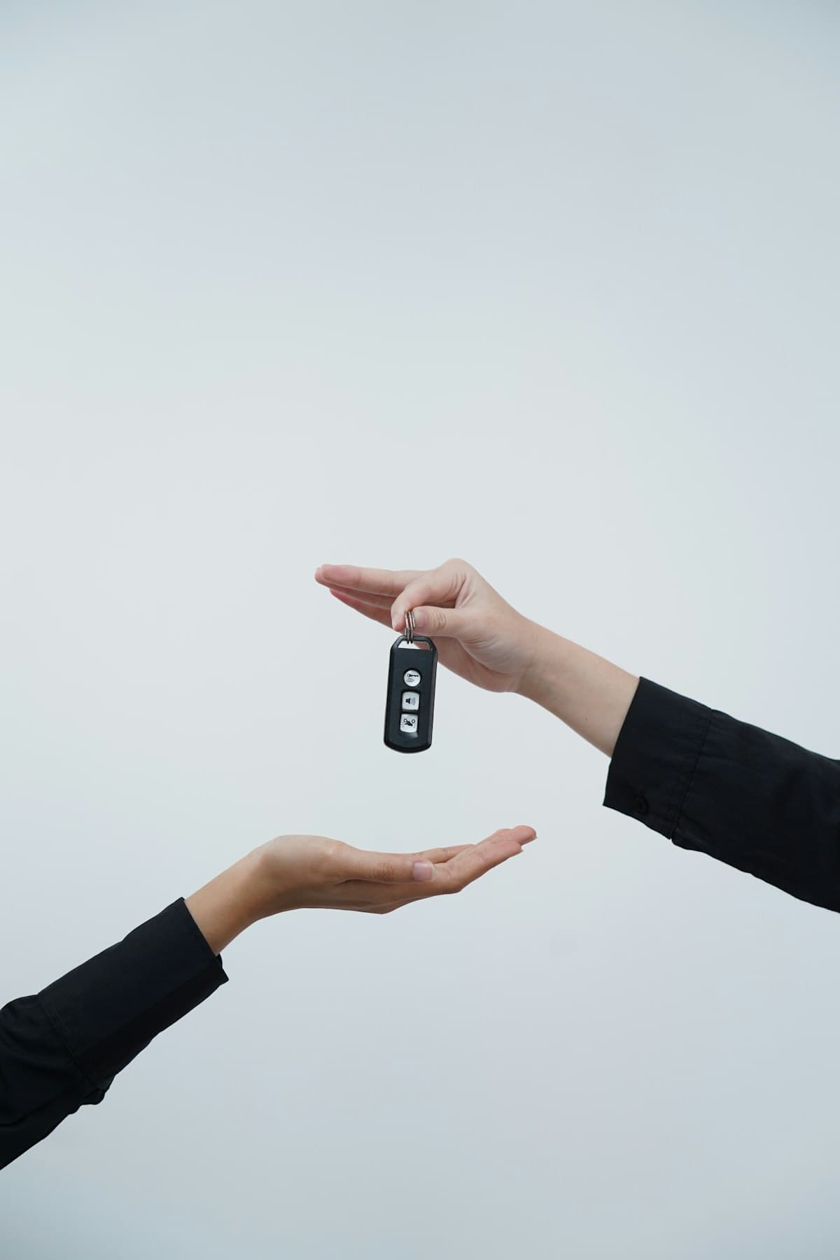One person handing a set of car keys to another